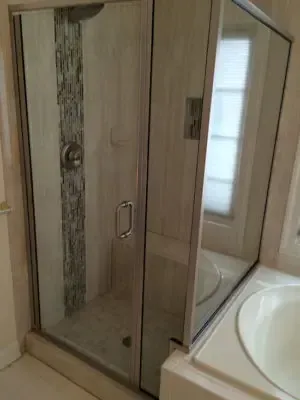 A bathroom with a walk in shower and a tub.