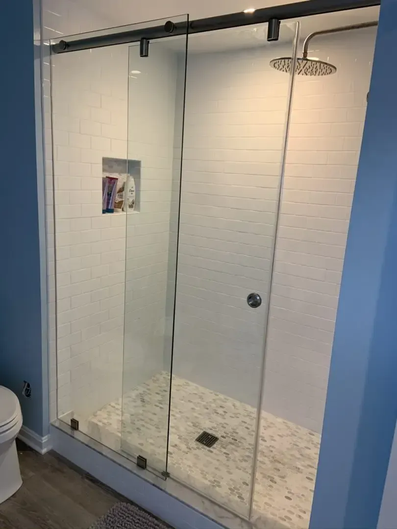 A bathroom with a sliding glass shower door and a toilet.