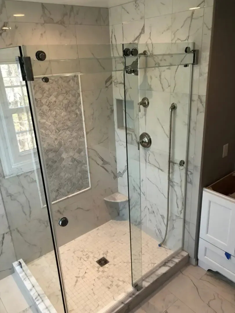 A bathroom with a sliding glass shower door