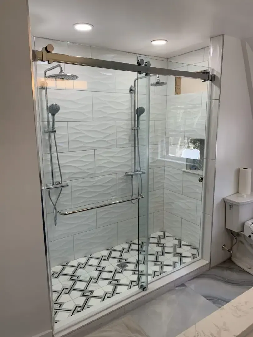 A bathroom with a sliding glass shower door and a toilet.