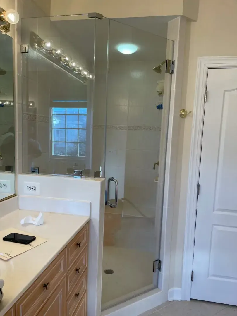 A bathroom with a walk in shower and a vanity.