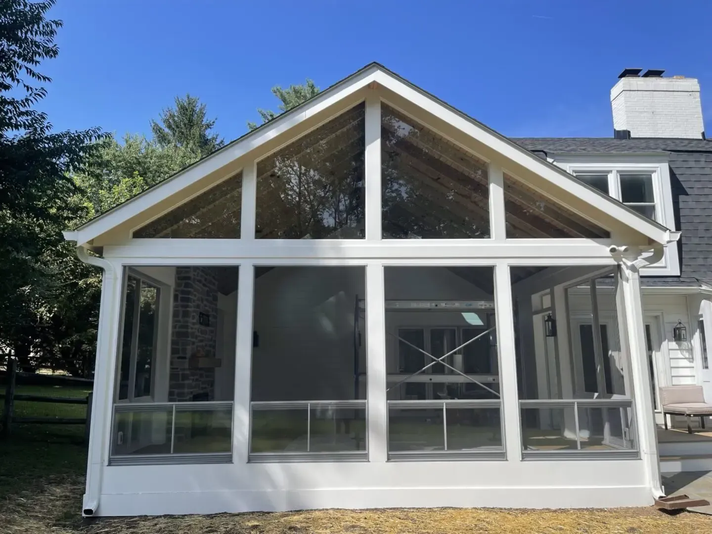 A screened in porch on the side of a house
