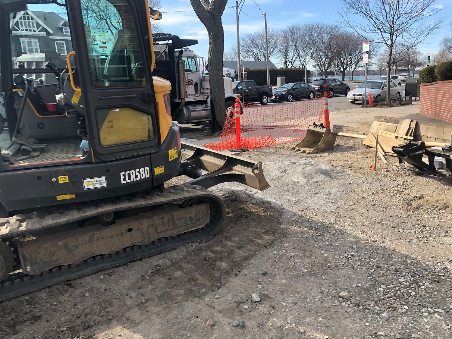 A yellow and black excavator is parked in a dirt lot.