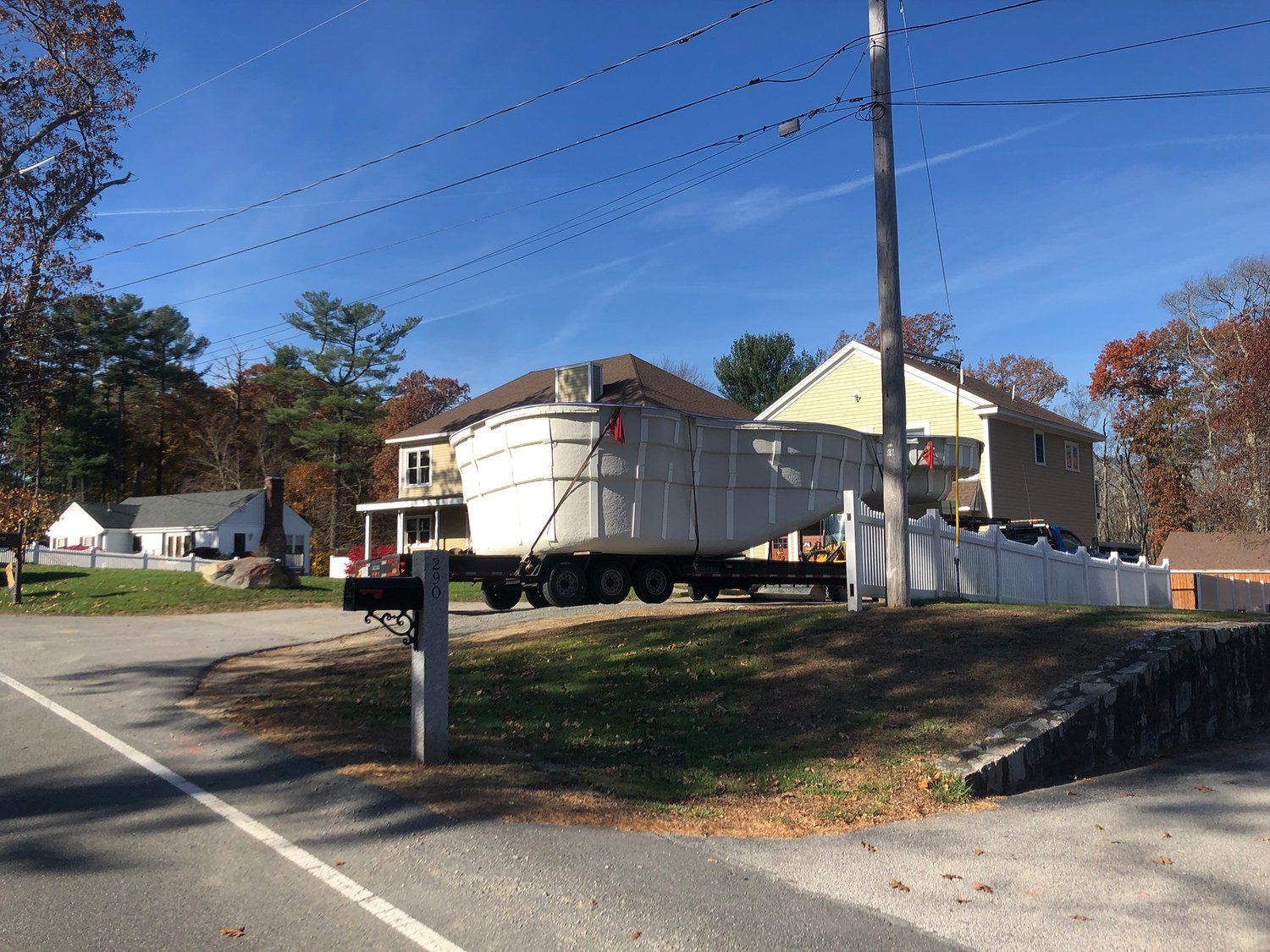 A dumpster is parked on the side of the road in front of a house.