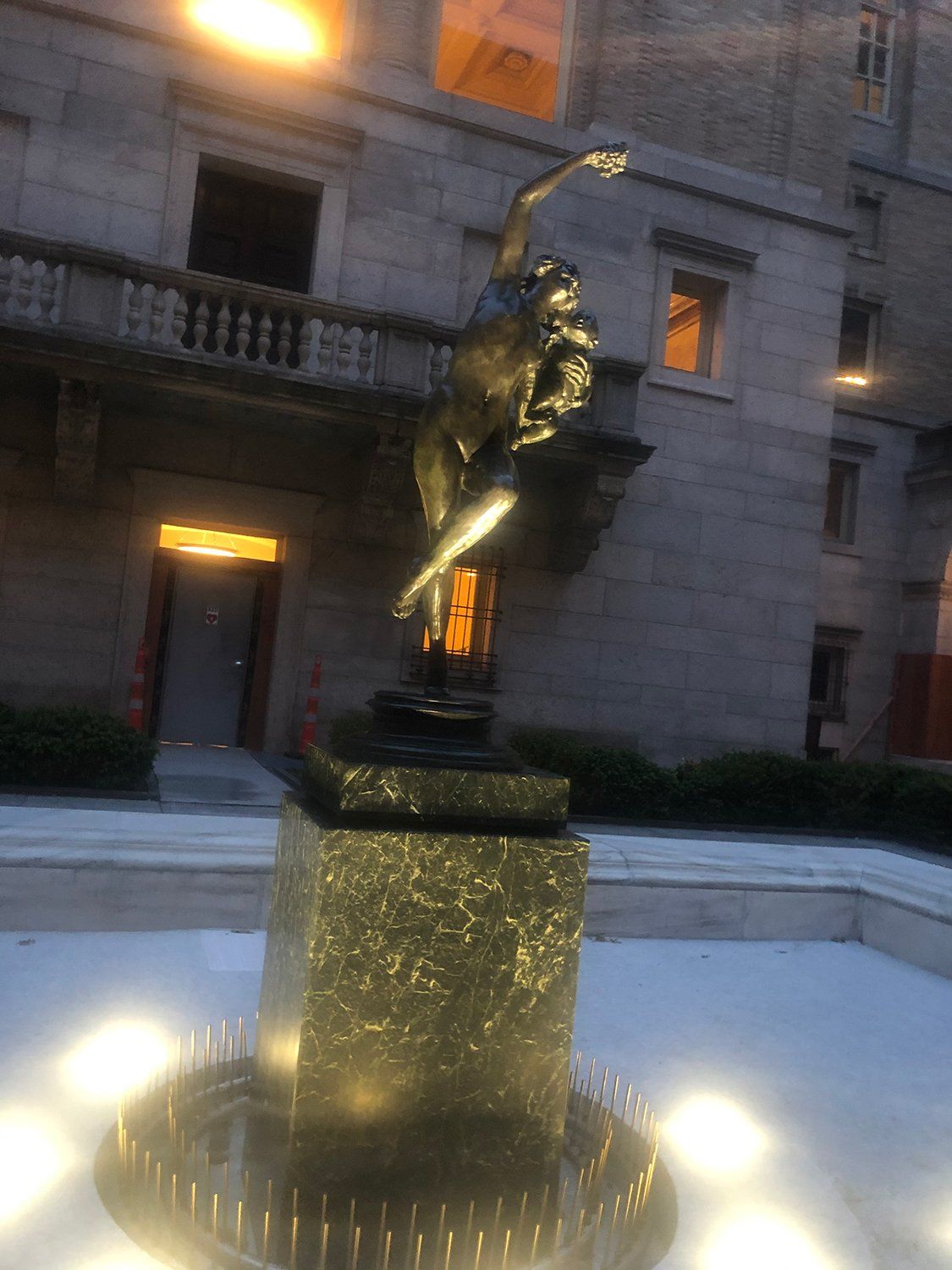 A statue of a man on a horse in front of a building