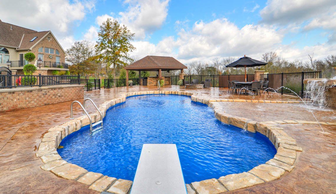 A large swimming pool with a diving board in the middle of it.