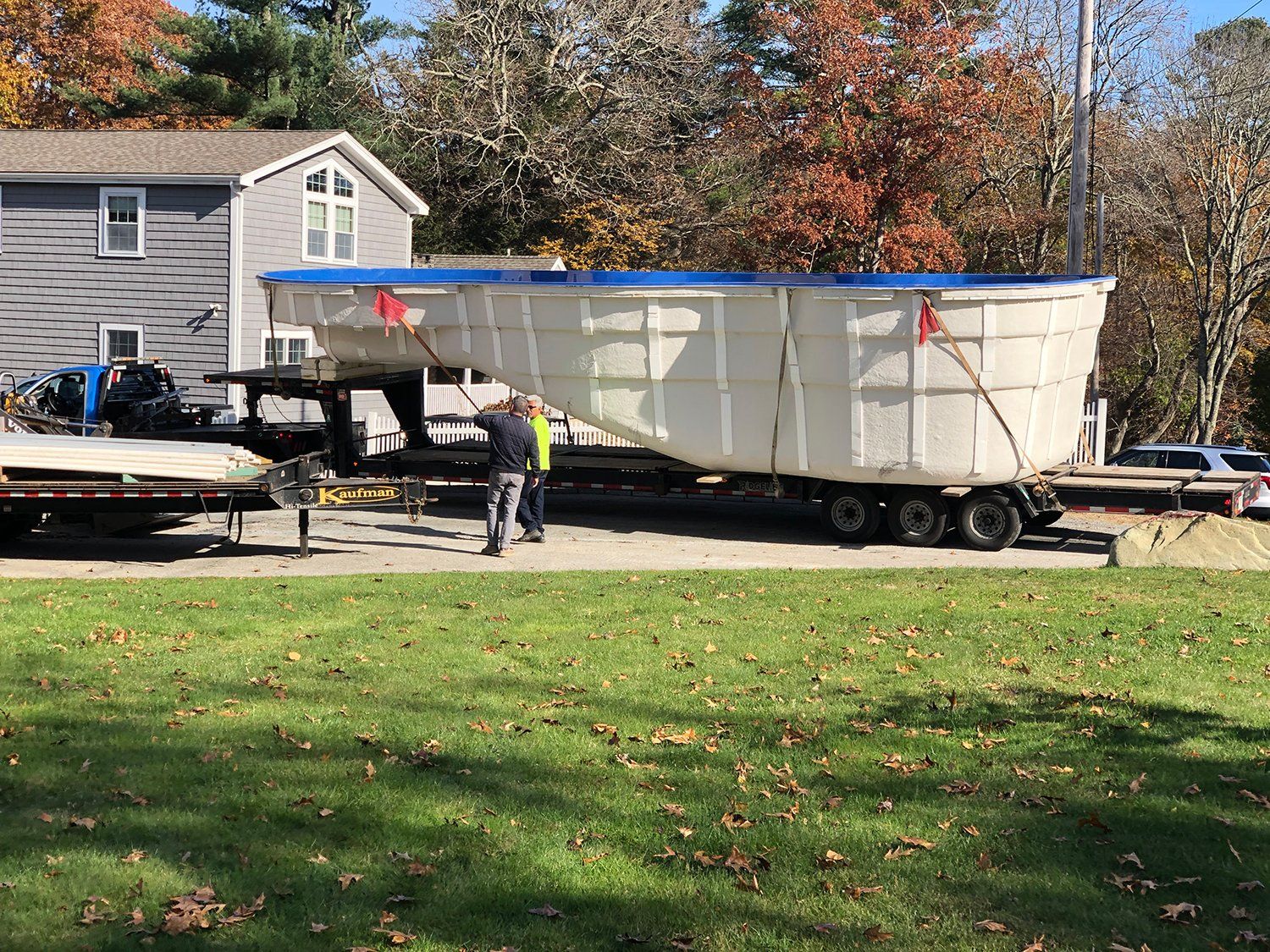 A large swimming pool is being transported on a trailer.