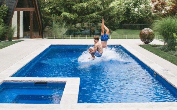A man is doing a handstand in a swimming pool.