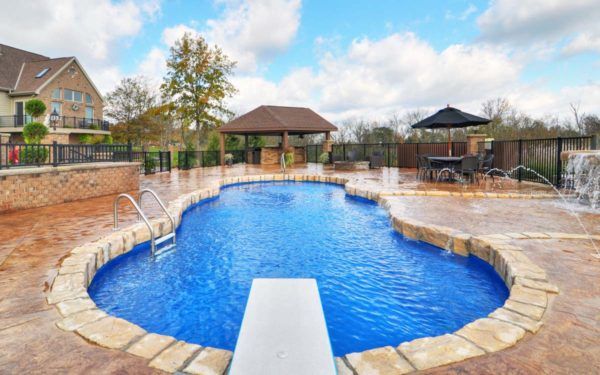 A large swimming pool with a diving board in the middle of it.