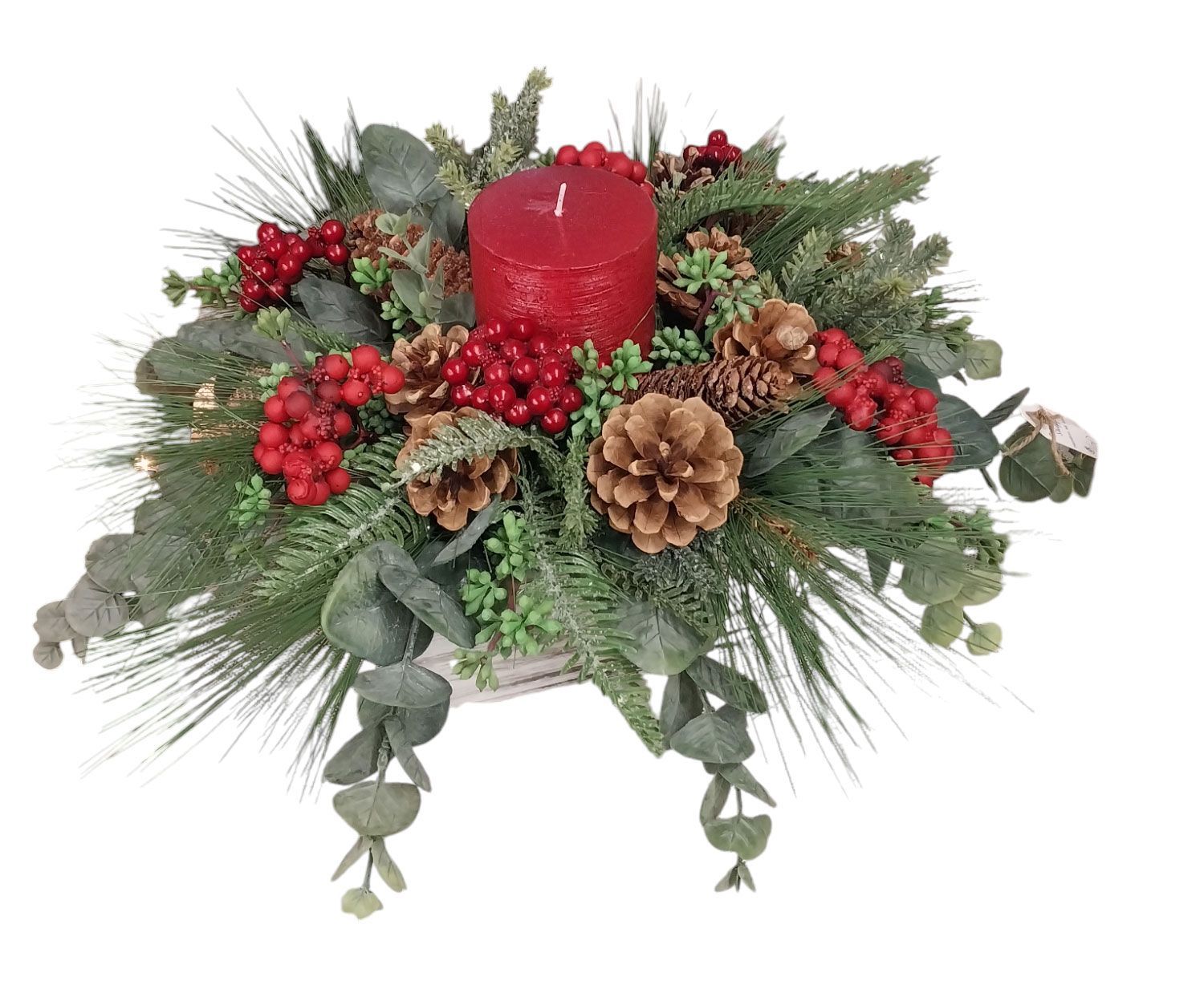 Christmas centerpiece with red candle, berries, pinecones, and evergreen foliage.