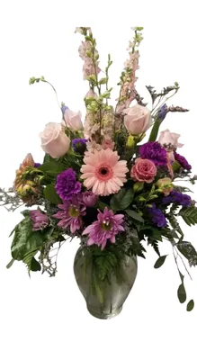 Floral arrangement in a glass vase with pink, purple, and green flowers.