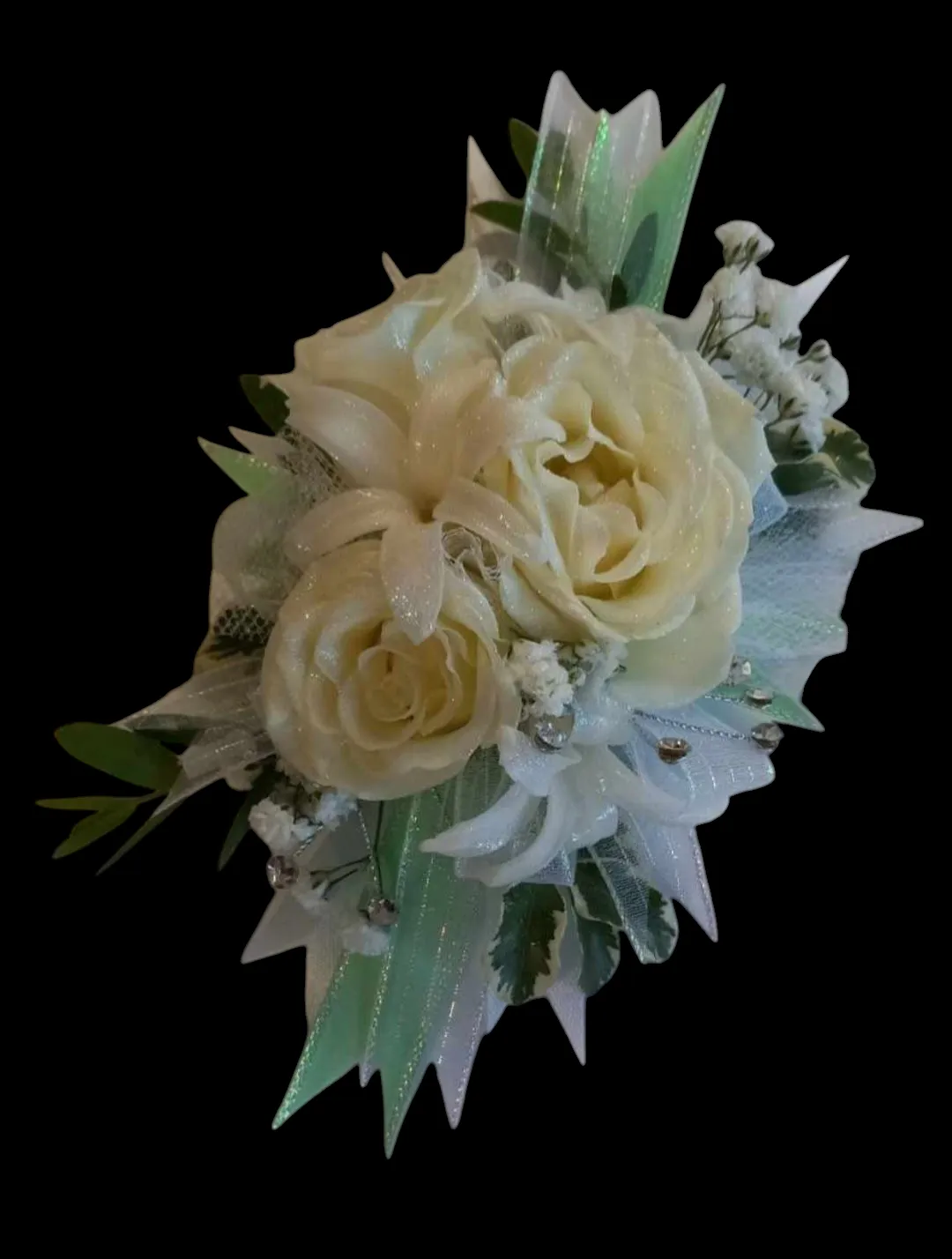 Cream-colored rose corsage with green accents and white netting against a black background.