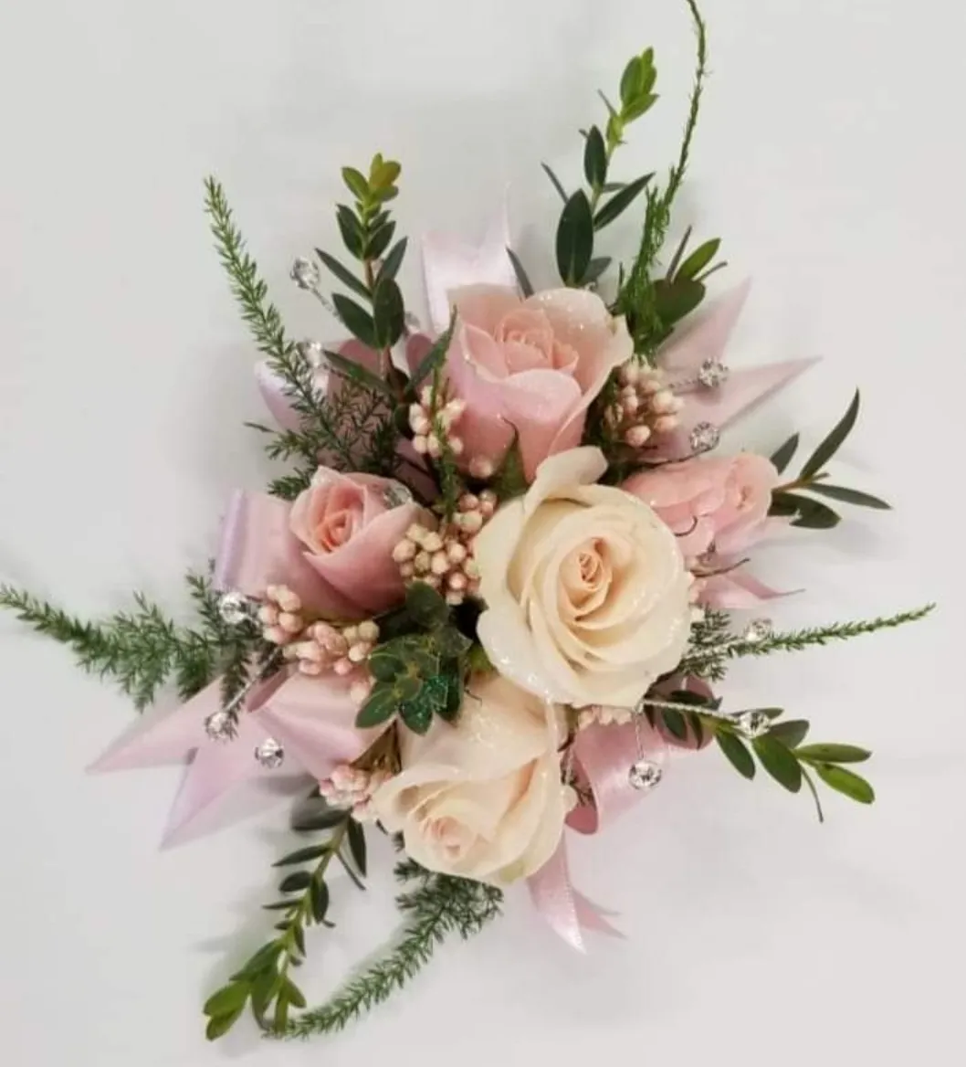 Pink and cream rose corsage with greenery and pink ribbon.