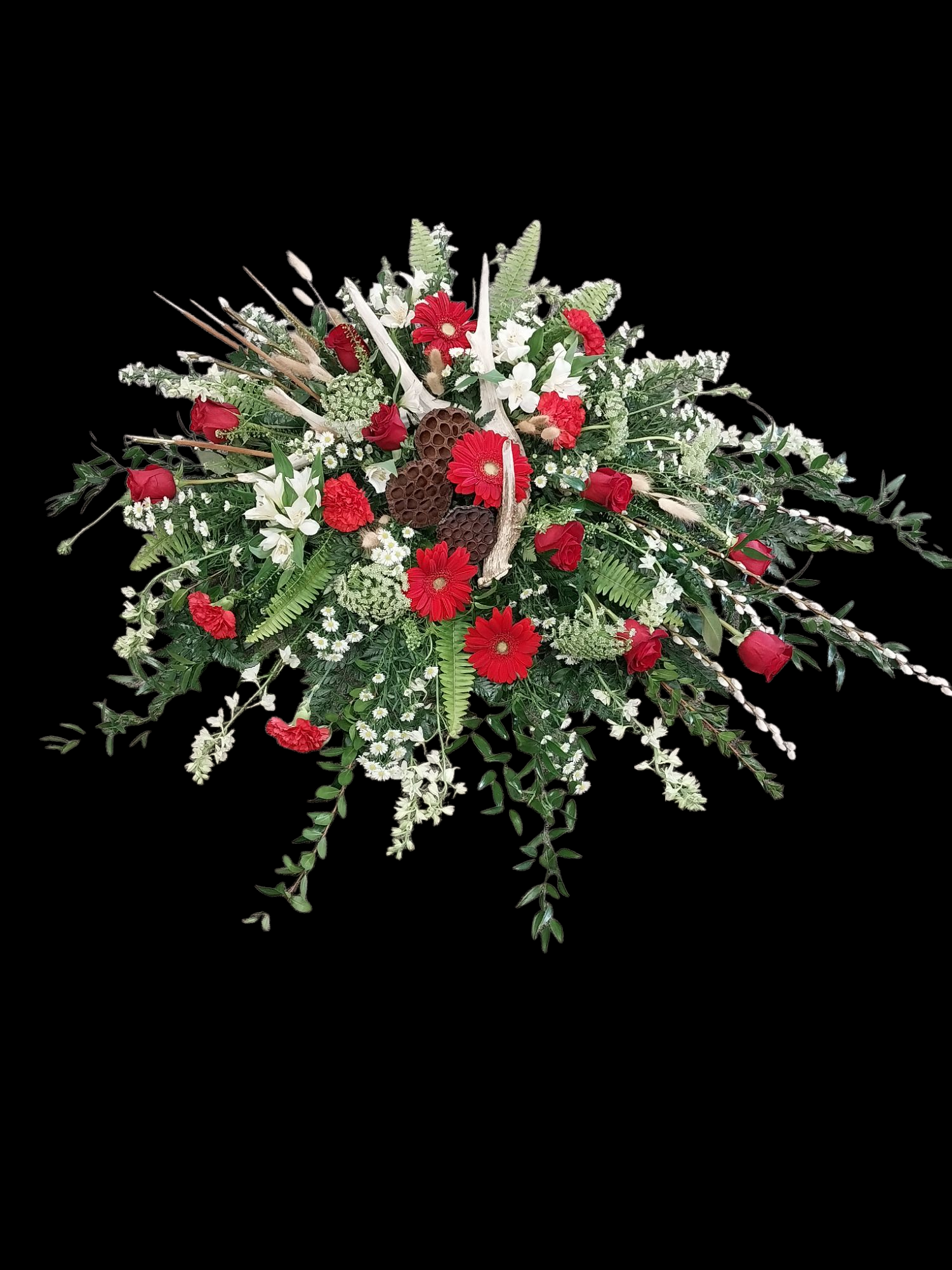 Red and white floral arrangement, possibly for a funeral, against a black background.