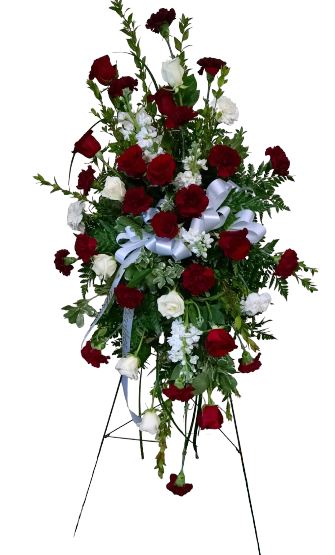 Standing floral arrangement with red carnations, white roses, and greenery, on a metal stand.