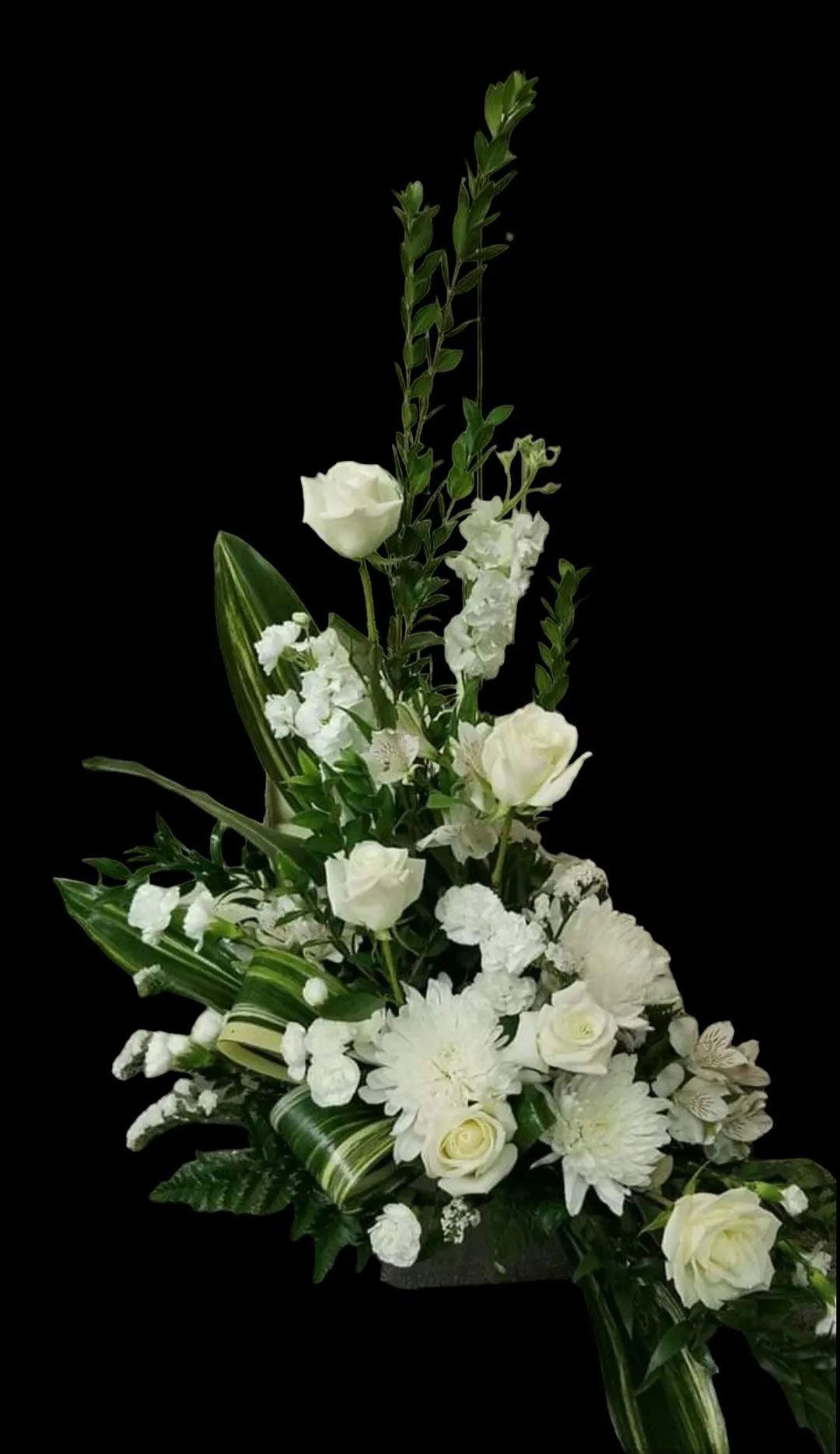 White flower arrangement on a black background. Includes roses, mums, and greenery.