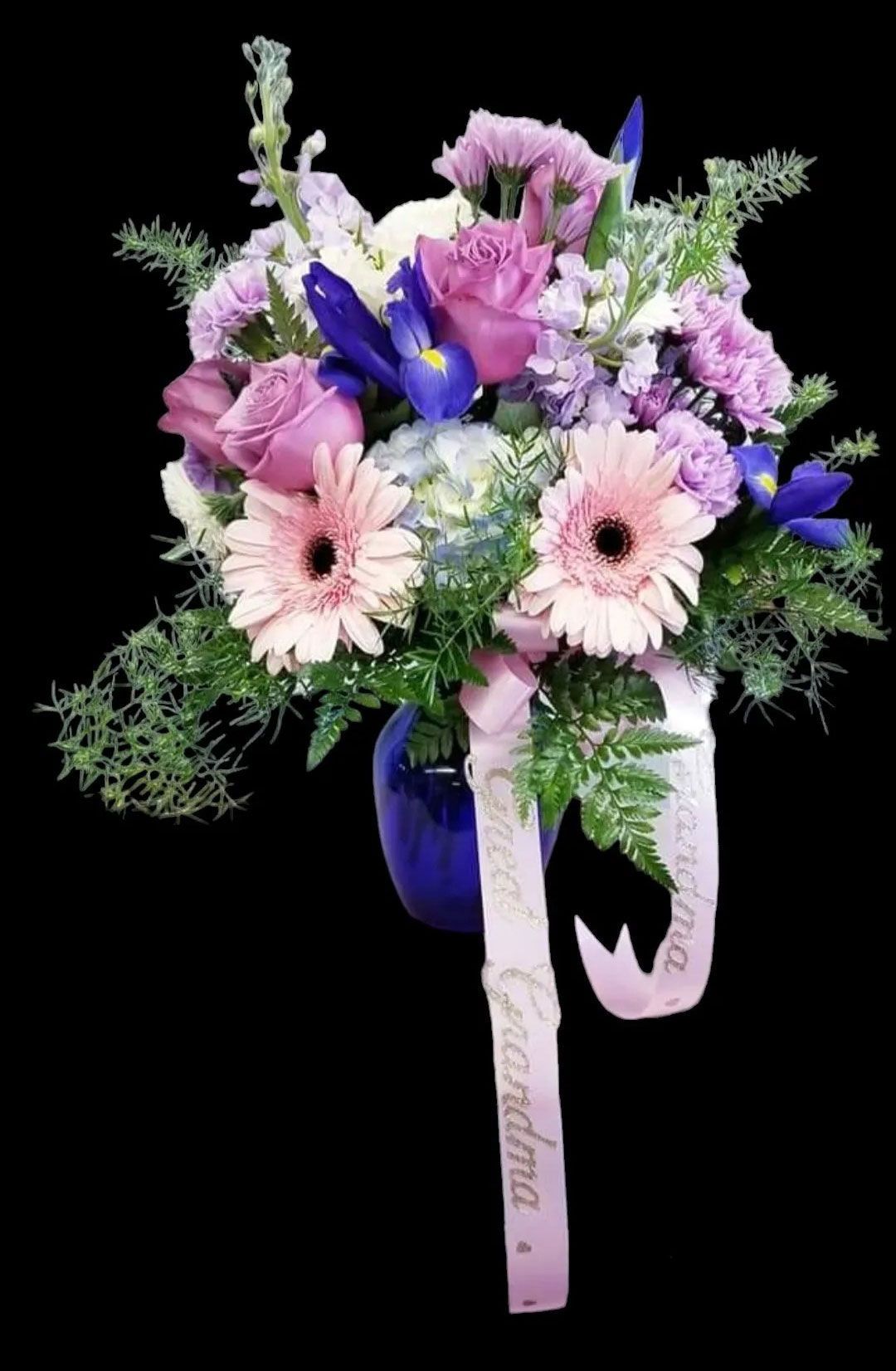 Bouquet of pink and purple flowers in a blue vase, with a ribbon that says 
