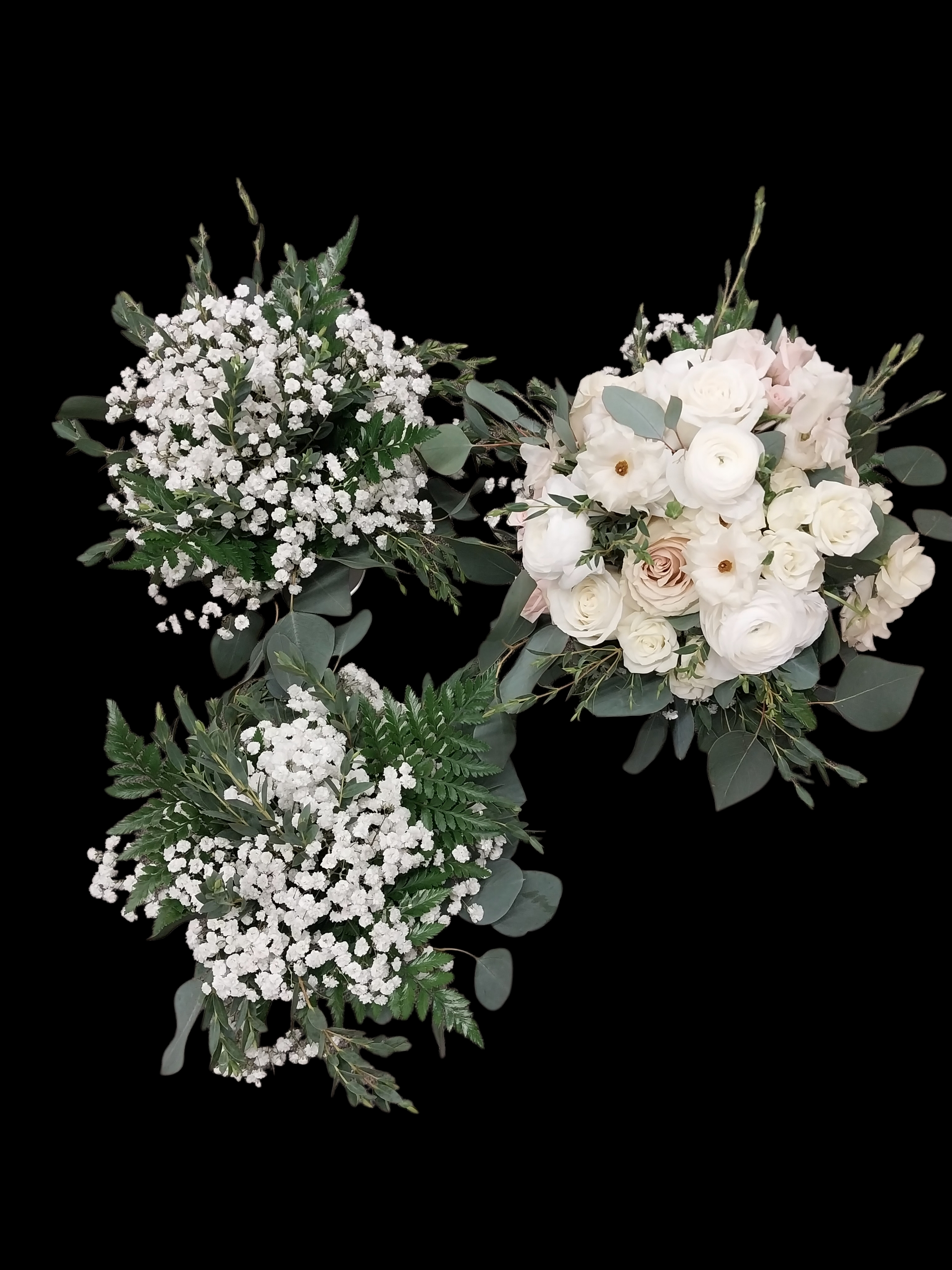 Three bouquets of white flowers with green foliage against a black background.