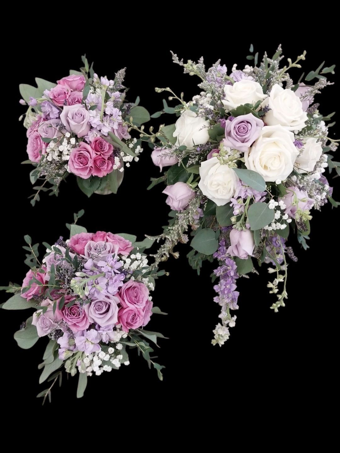 Three bouquets of pink and purple flowers with greenery against a black background.