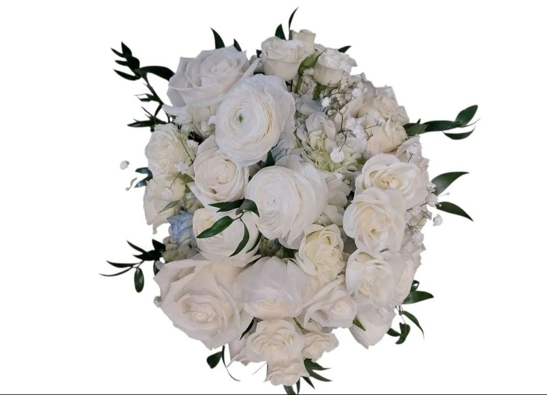 White floral bouquet with roses, ranunculus, and sprigs of green foliage.