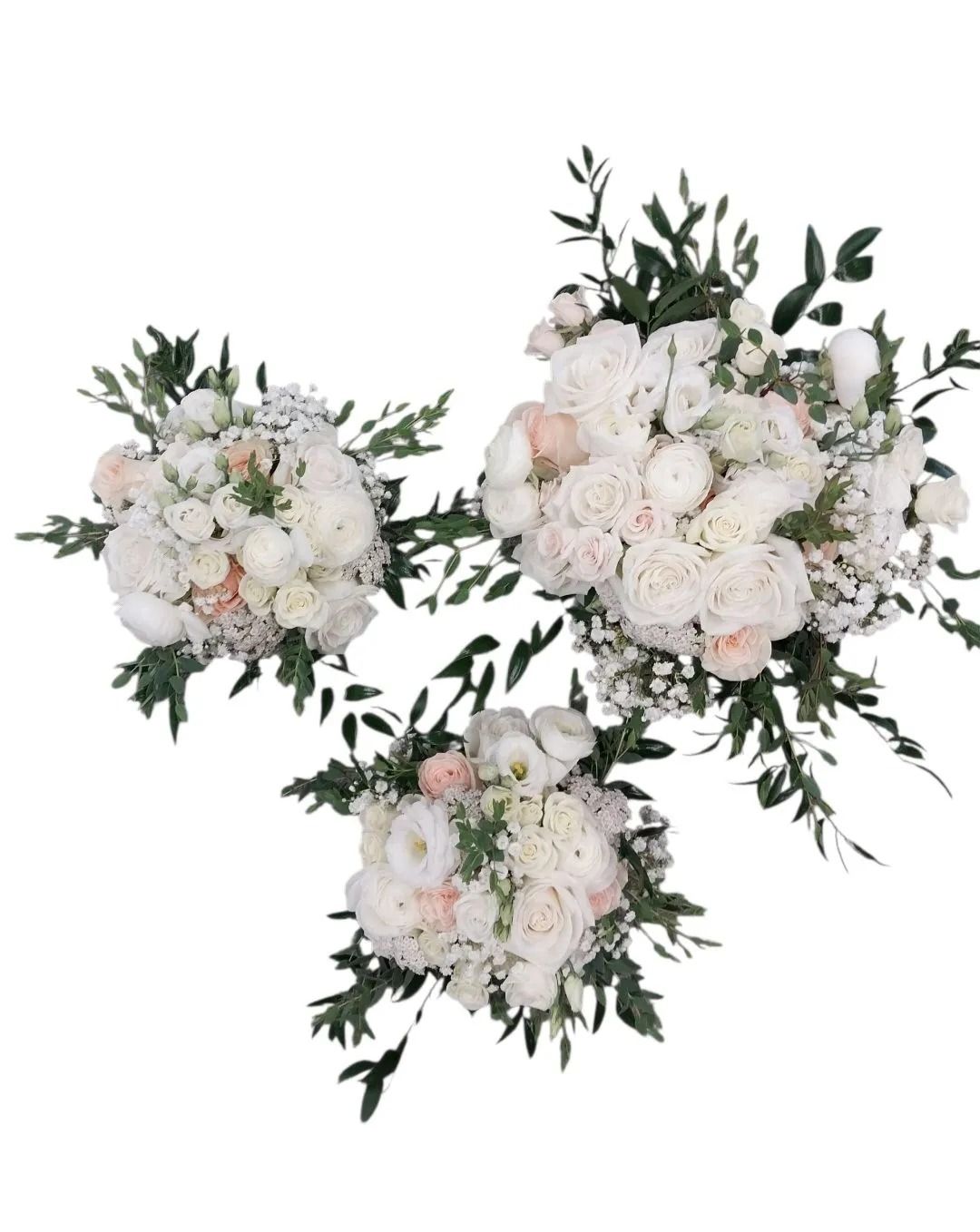 Three white flower bouquets with greenery.
