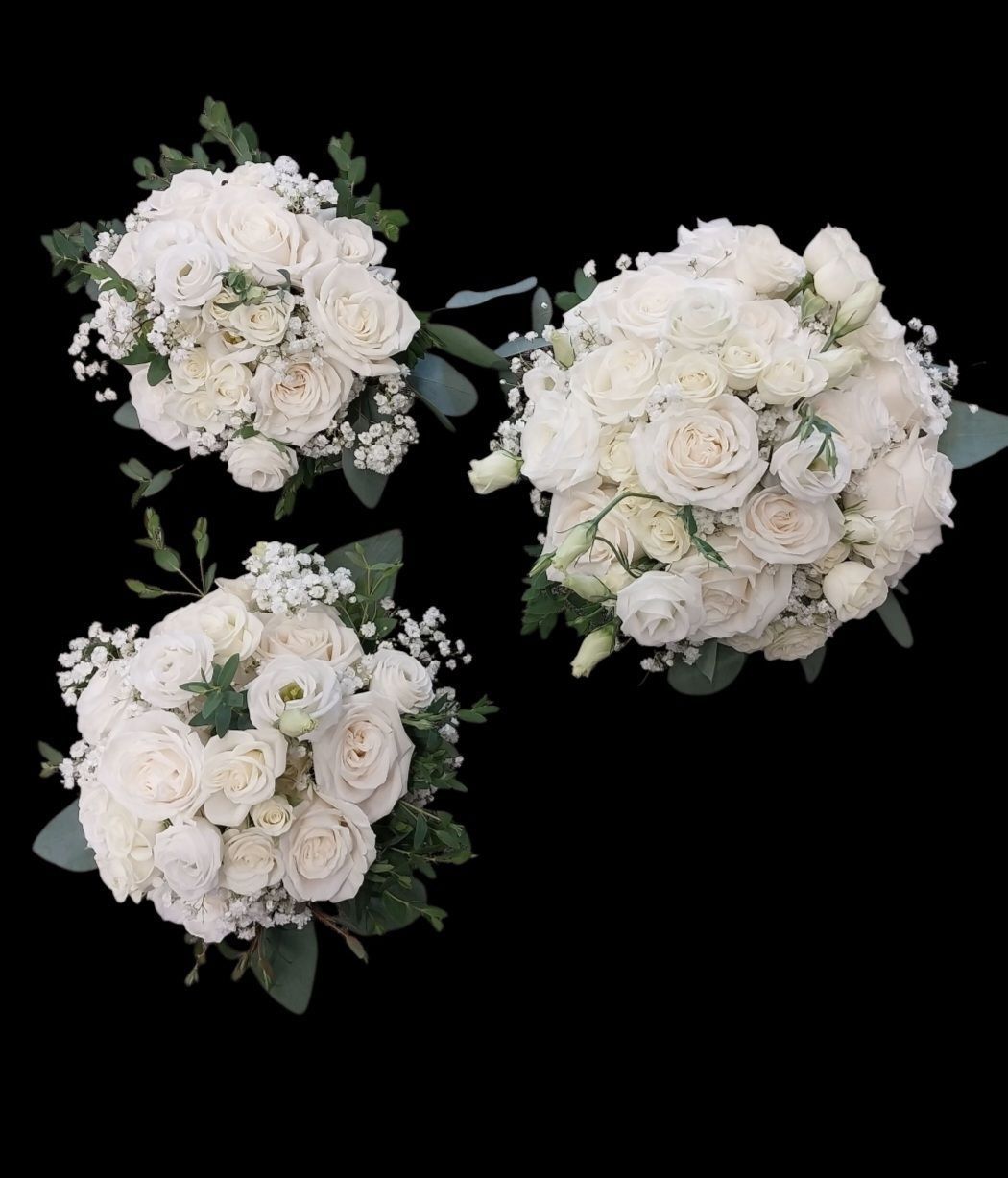 Three round bouquets of white roses and greenery on a black background.