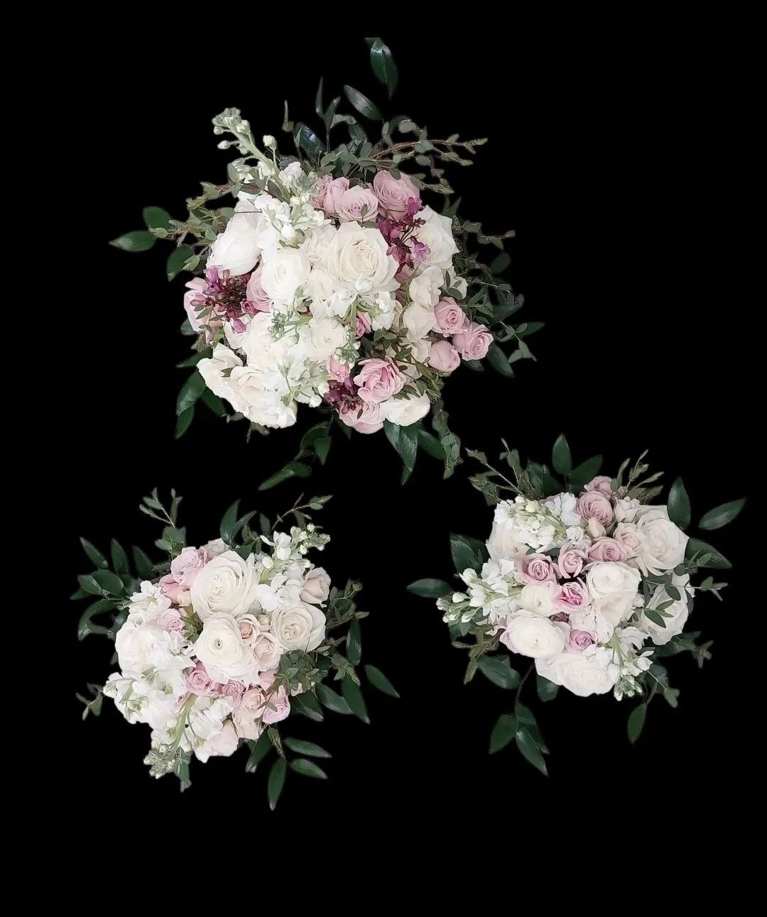 Three bouquets of white and pink flowers with green foliage, arranged against a black background.