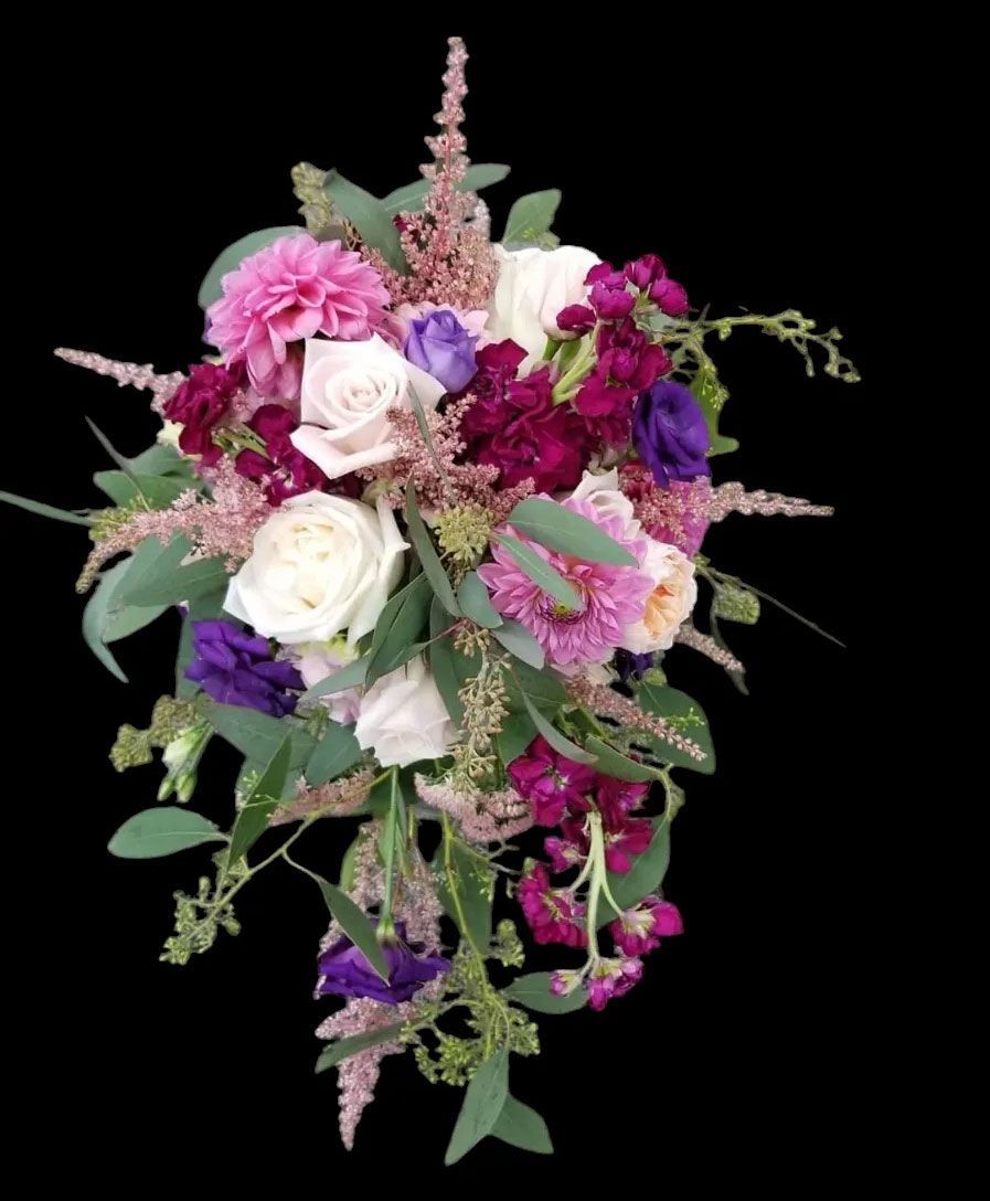 Cascading bouquet with white, purple, and burgundy flowers; green foliage on black background.