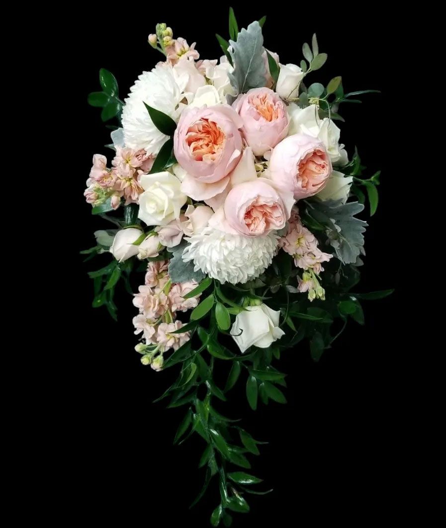 Elegant bouquet with pink peonies, white roses, and greenery on black background.