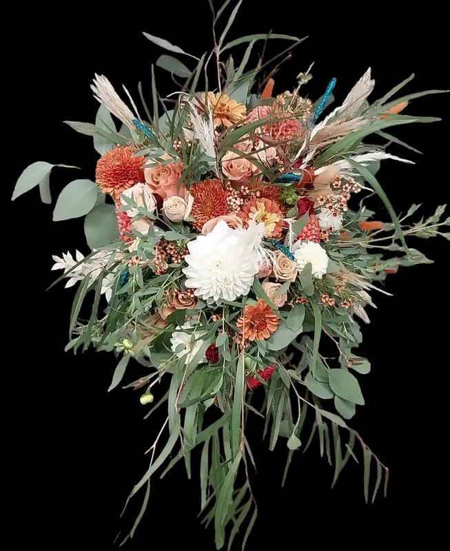 Colorful floral bouquet with white and orange blooms, eucalyptus, and dried accents against a black background.
