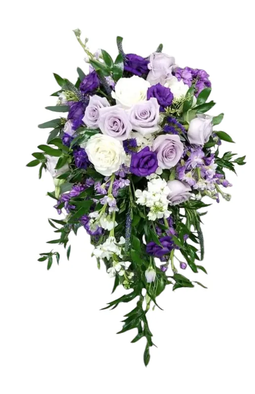 Cascading bouquet of white and purple roses, accented with greenery and other purple flowers.