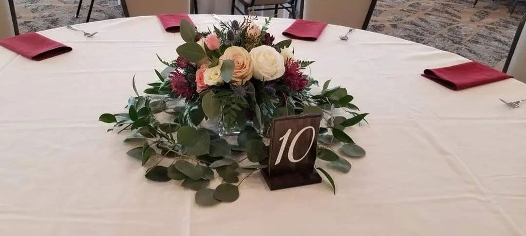Round table set for a wedding, with floral centerpiece and table number 10.