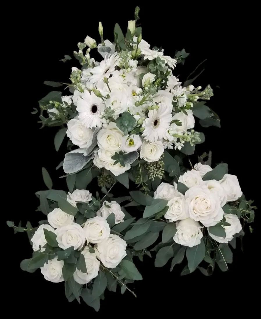 Three bouquets of white flowers and greenery against a black background.