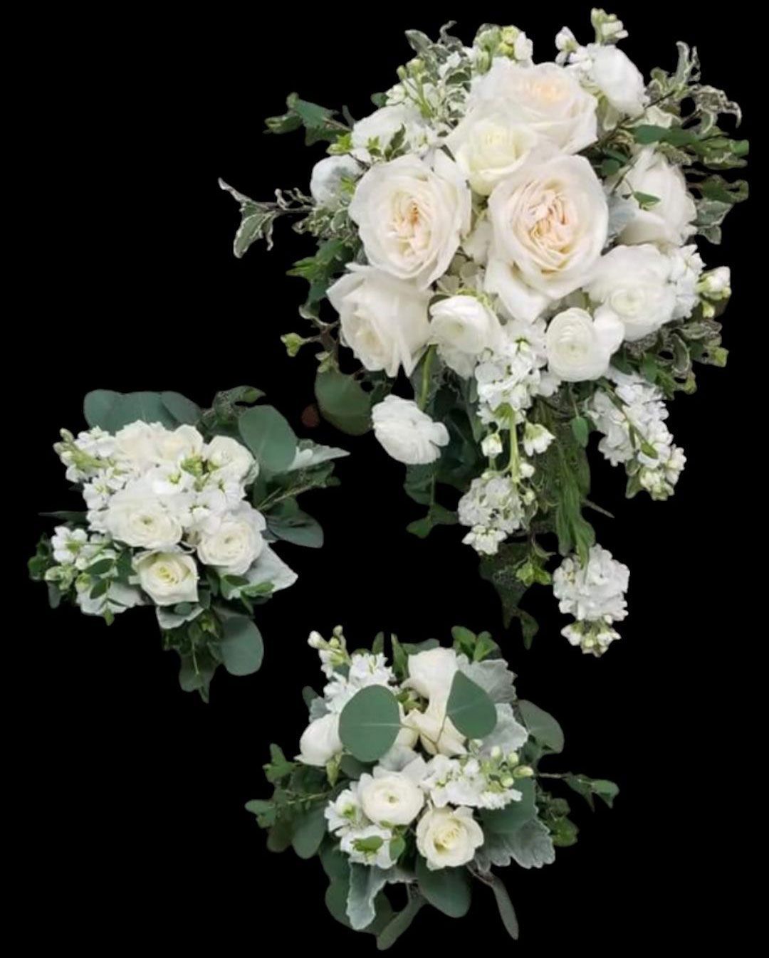 Three white bouquets with roses and greenery on a black background.