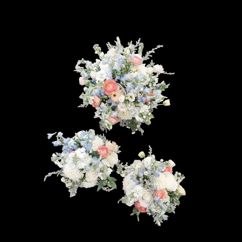 Three bouquets with blue, white, and peach flowers on a black background.