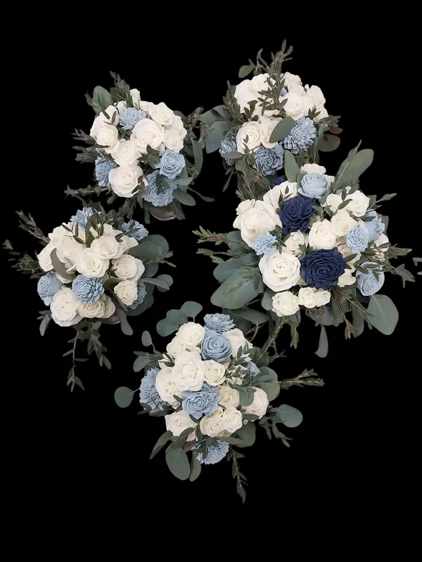 Five floral bouquets with white, blue, and navy flowers and green foliage arranged against a black background.