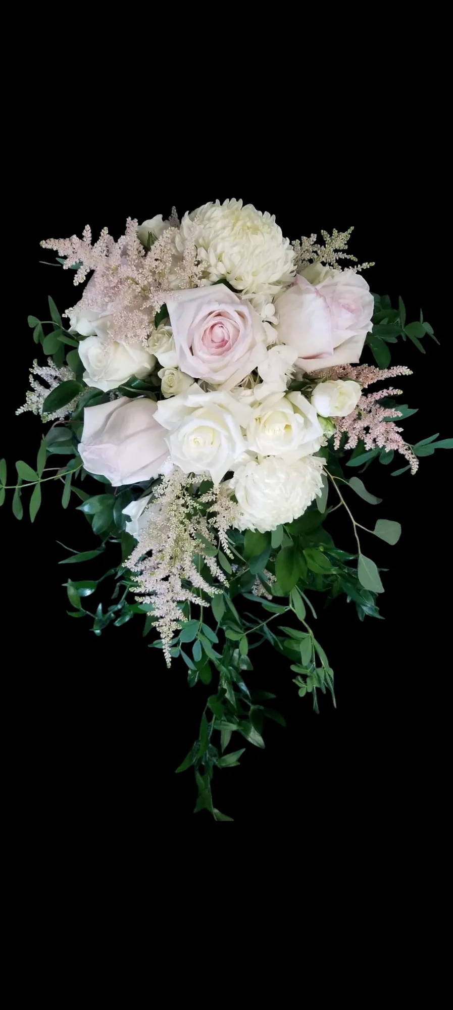 A bouquet of light pink and white flowers with green foliage, set against a black background.