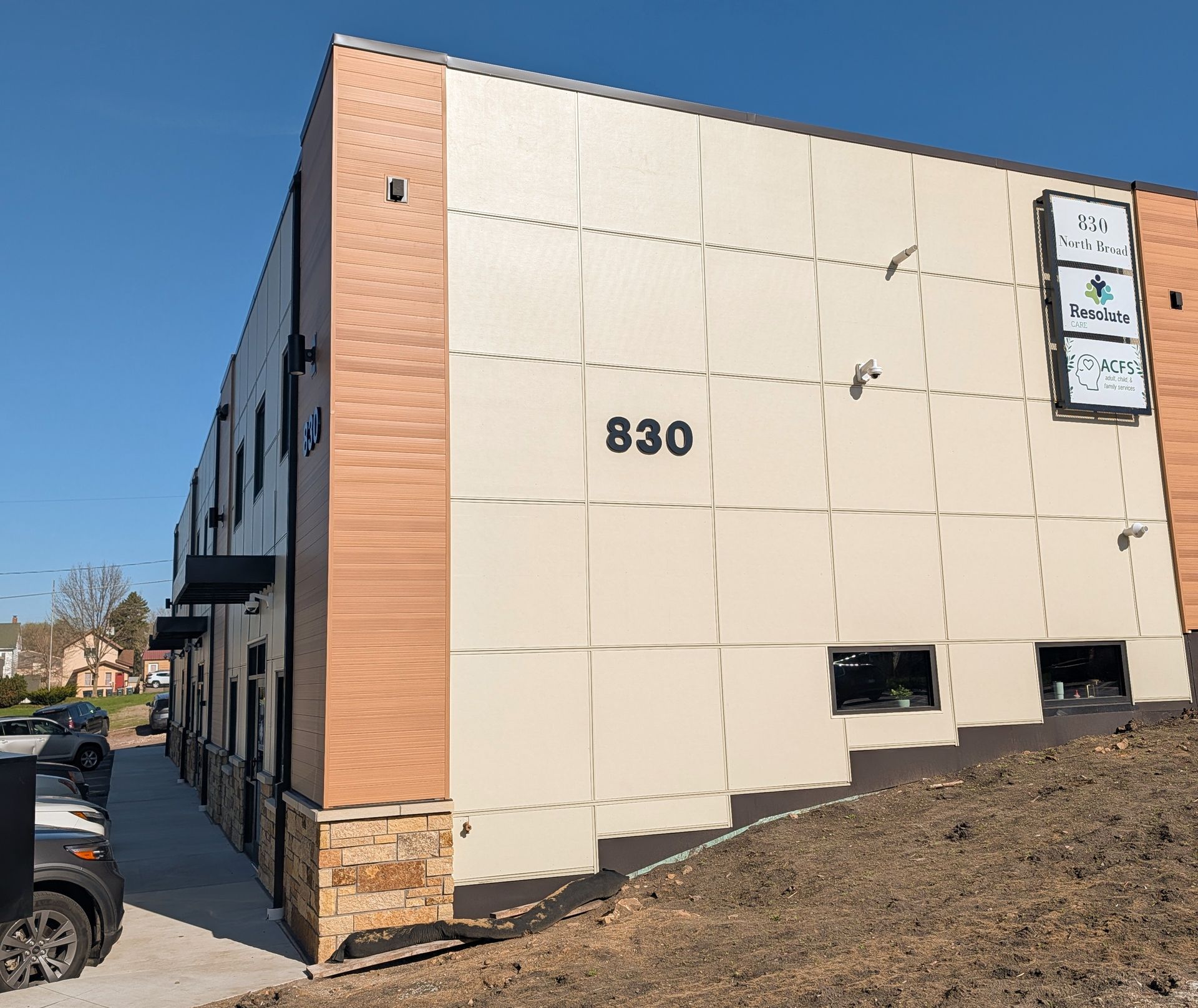 Exterior of a beige commercial building with brick trim and the number 830 visible