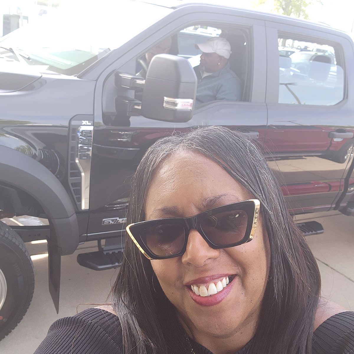 A black truck behind a woman