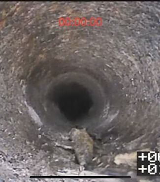 A camera is taking a picture of a hole in the ground.