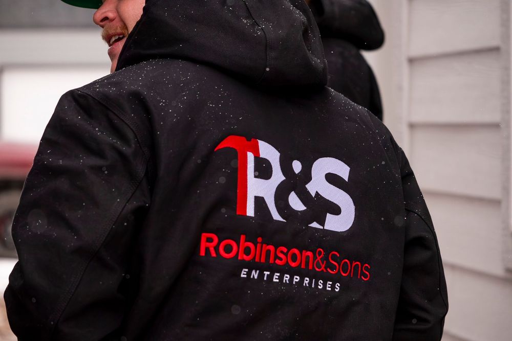 Yellow construction tools: hard hat, ear muffs, tool belt with tape measure, pencil, and pliers on a wood surface.