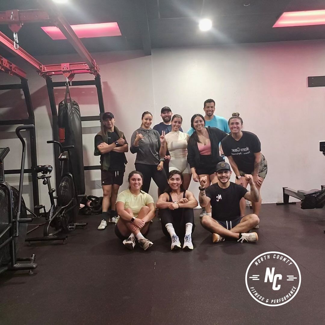 A group of people are posing for a picture in a gym.