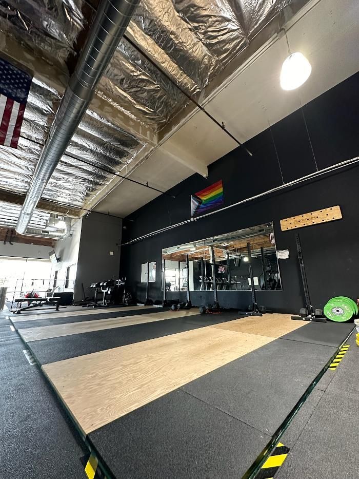 A large gym with a rainbow flag on the wall.