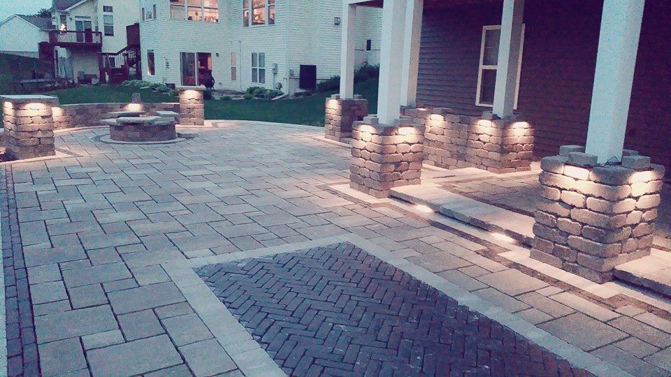 Brick patio with built-in lighting and stone pillars