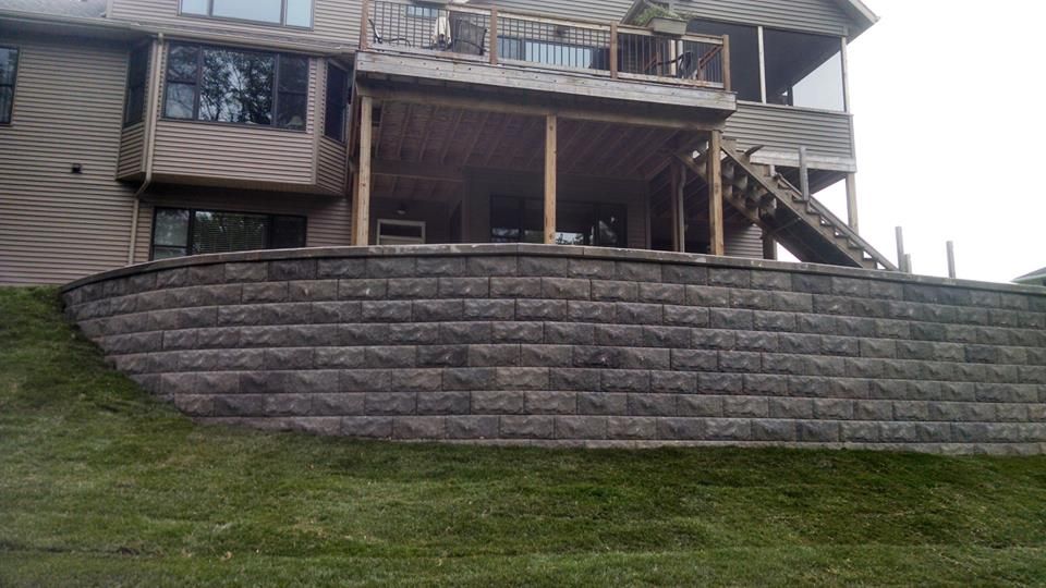 Stone retaining wall in front of a house on a slight hill