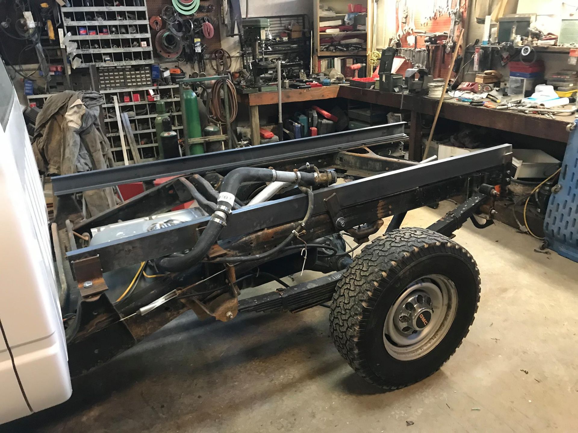 A truck is sitting in a garage with a trailer attached to it.