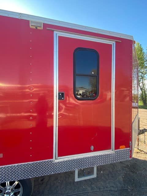 A red trailer with a window on the side