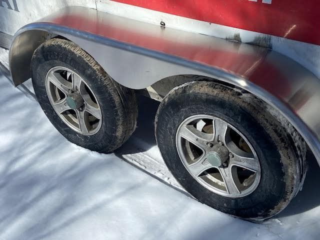 A close up of a trailer 's wheels in the snow