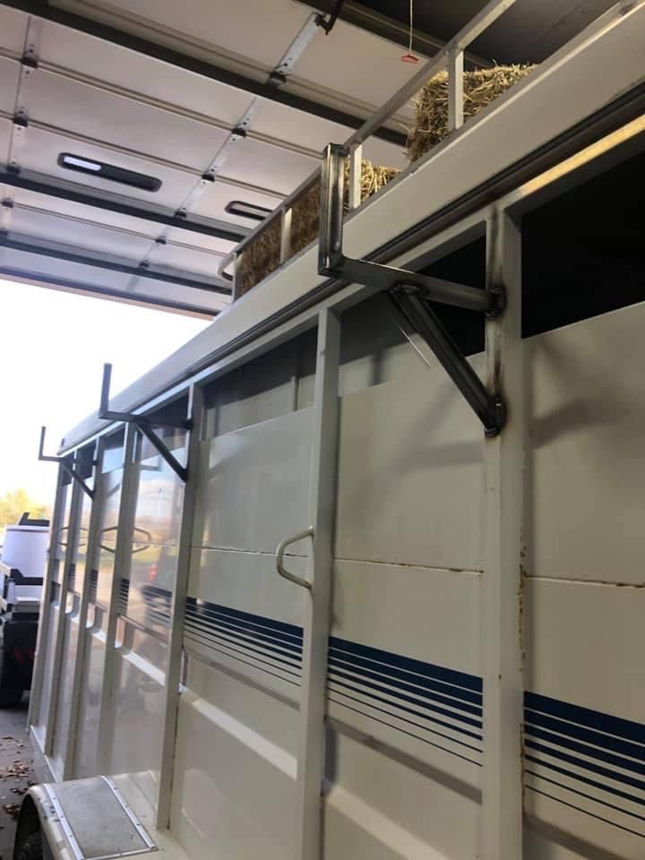 A white trailer with hay on top of it in a garage.