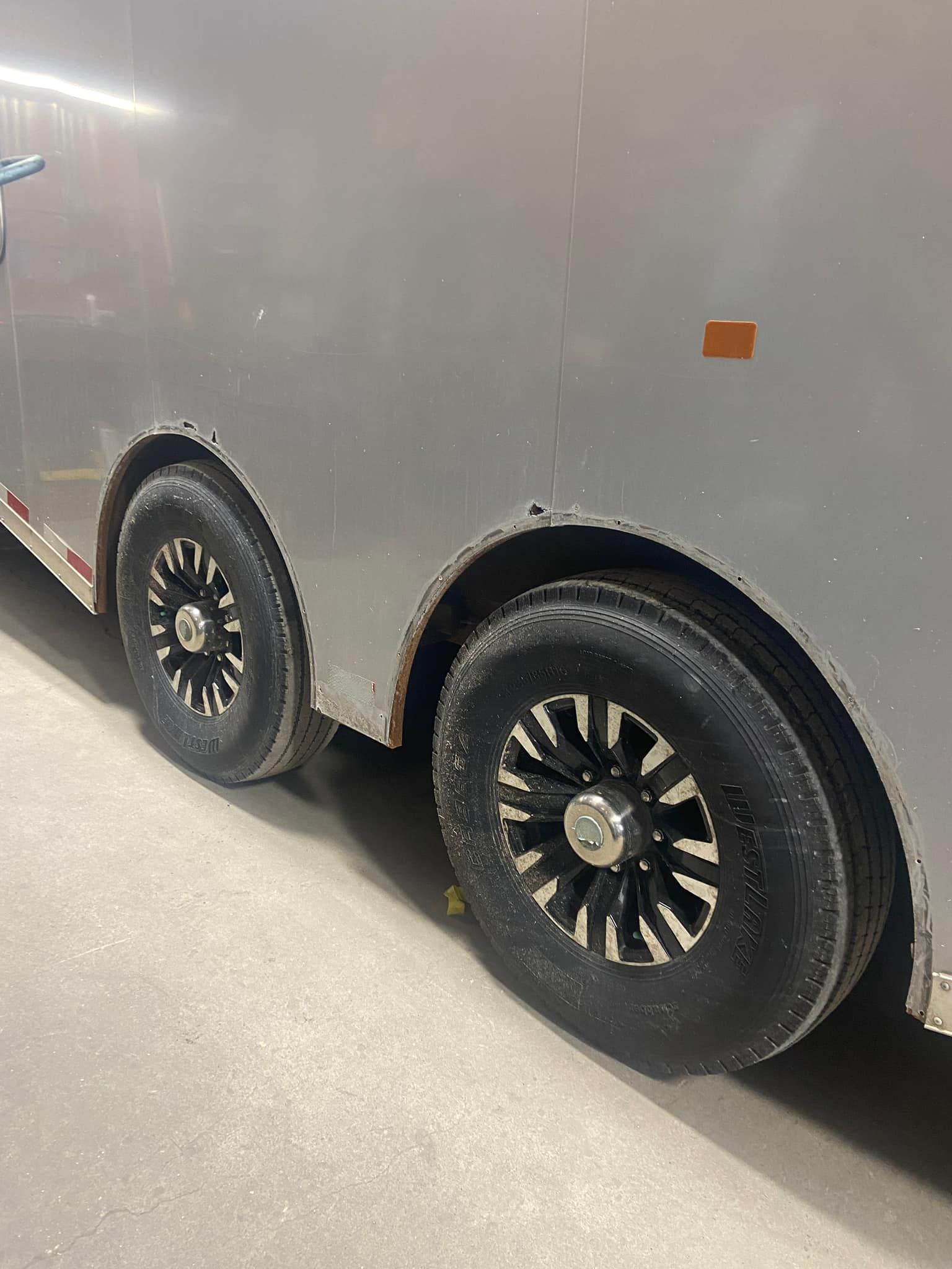 A close up of a trailer 's wheels and tires.